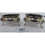 A pair of early Victorian silver, circular salt cellars, on shell cast and paw feet,