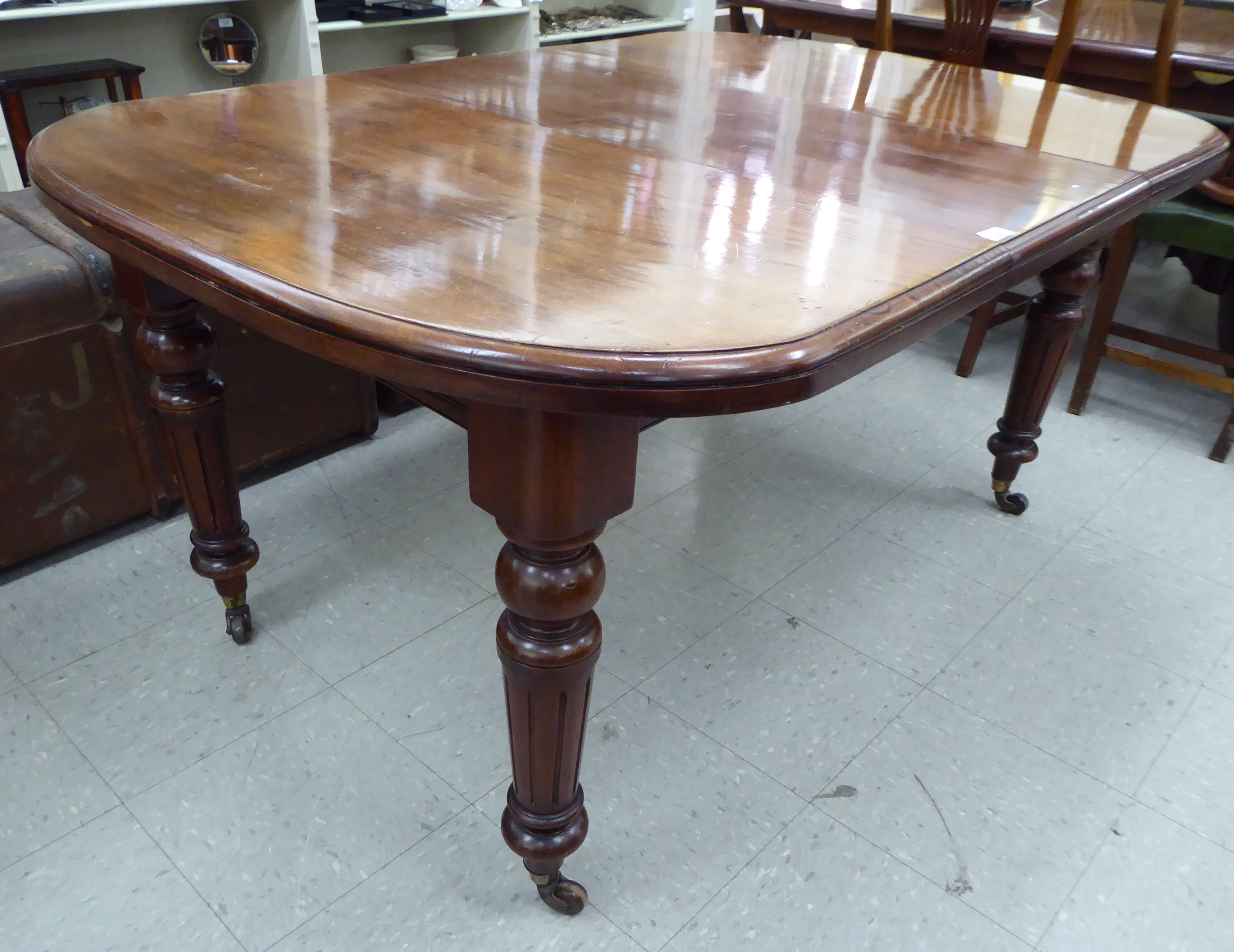 A late Victorian mahogany wind-out dining table, the top with a curved edge, raised on tapered, - Image 3 of 5