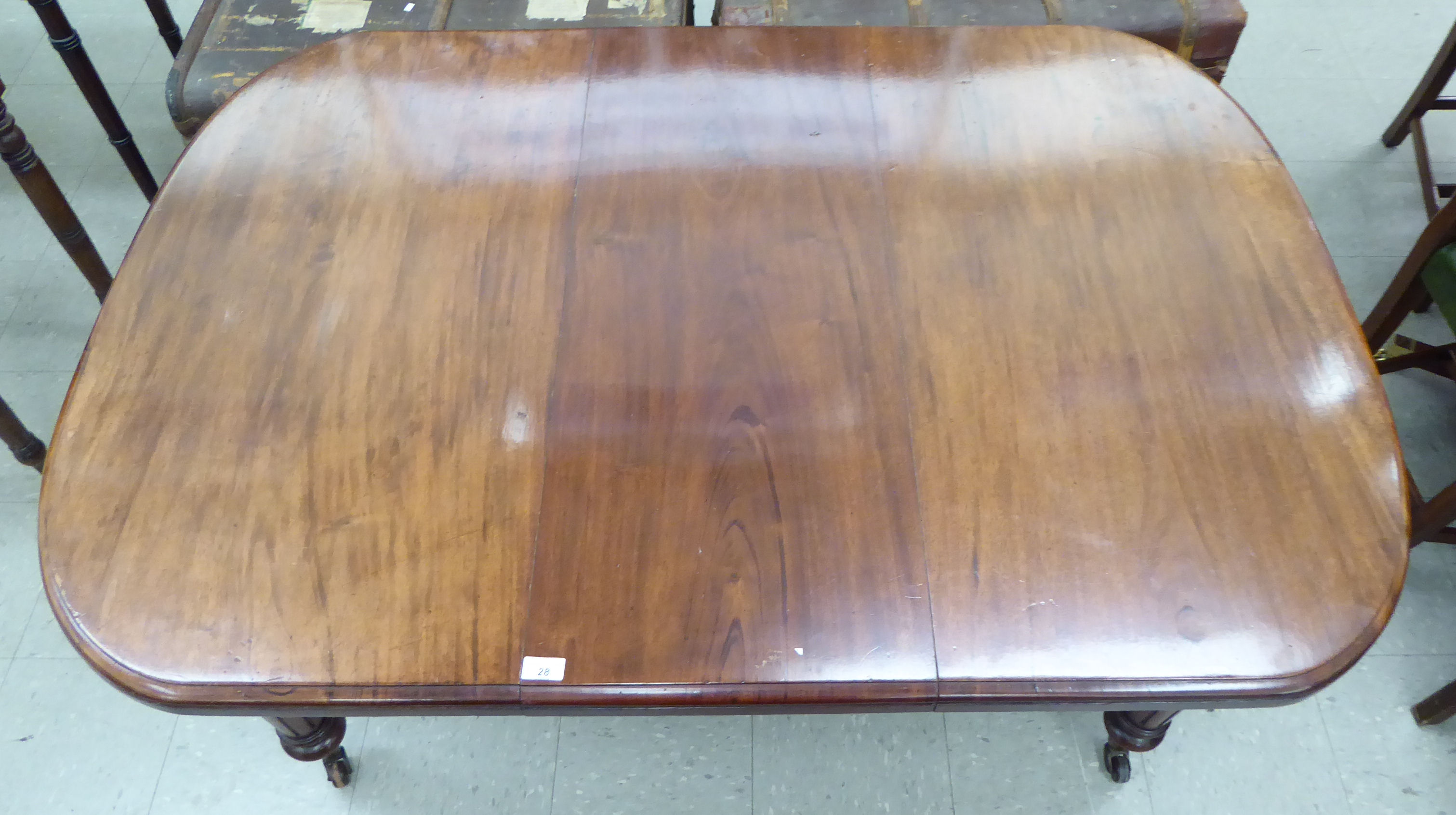 A late Victorian mahogany wind-out dining table, the top with a curved edge, raised on tapered, - Image 2 of 5
