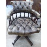 A modern mahogany framed captain's style desk chair, part-button upholstered in grey hide,