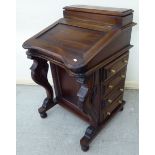 A modern mahogany finished Canterbury with a hinged top, four side drawers and opposing facsimiles,