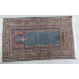 A Persian prayer rug, decorated in colours,