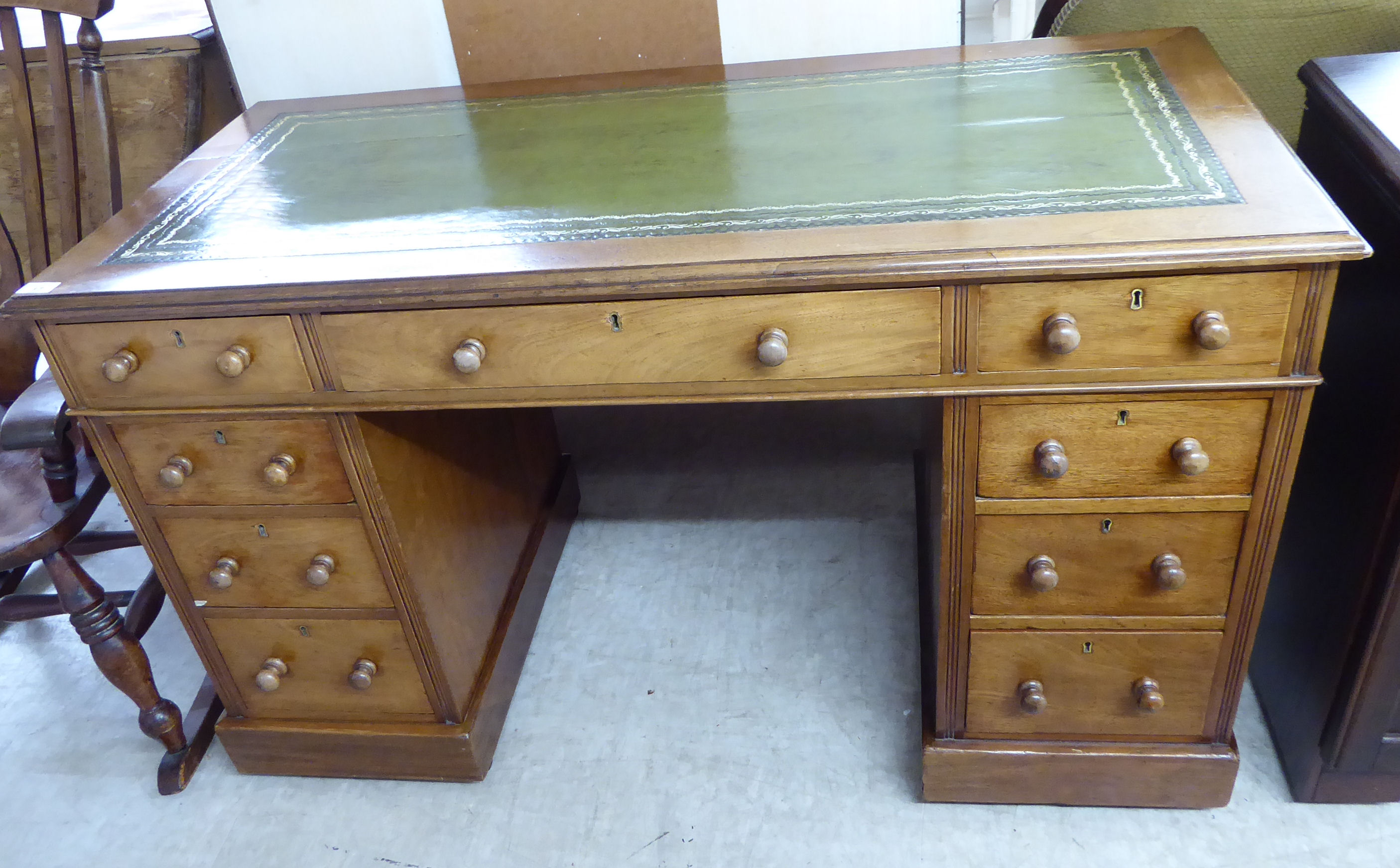 An early 20thC lady's mahogany twin pedestal, nine drawer desk,