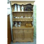 A modern pine dresser, the superstructure with two plate racks and four drawers,