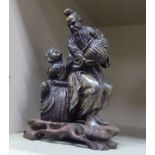 WITHDRAWN An 'antique' carved soapstone group, a bearded man with a child,