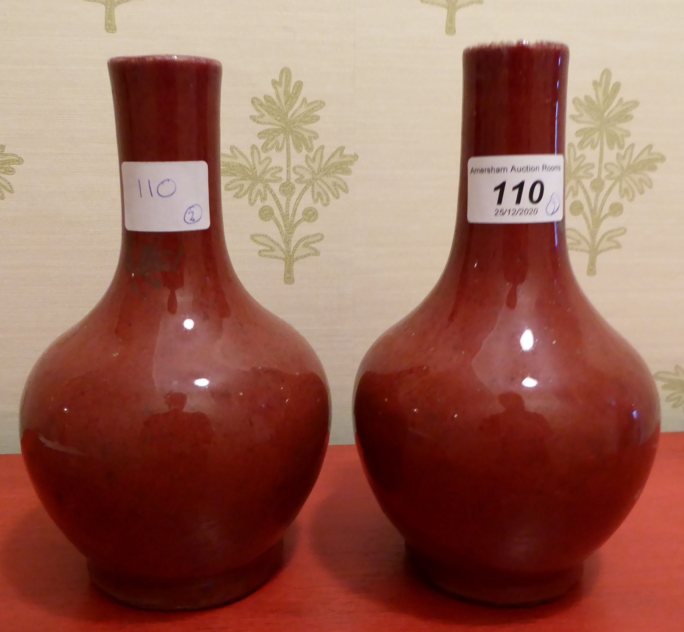 A pair of 20thC Chinese sang de boeuf porcelain vases of bulbous form with narrow necks 11''h