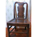 A mid 18thC oak framed hall chair with a vase shaped splat and panelled seat,