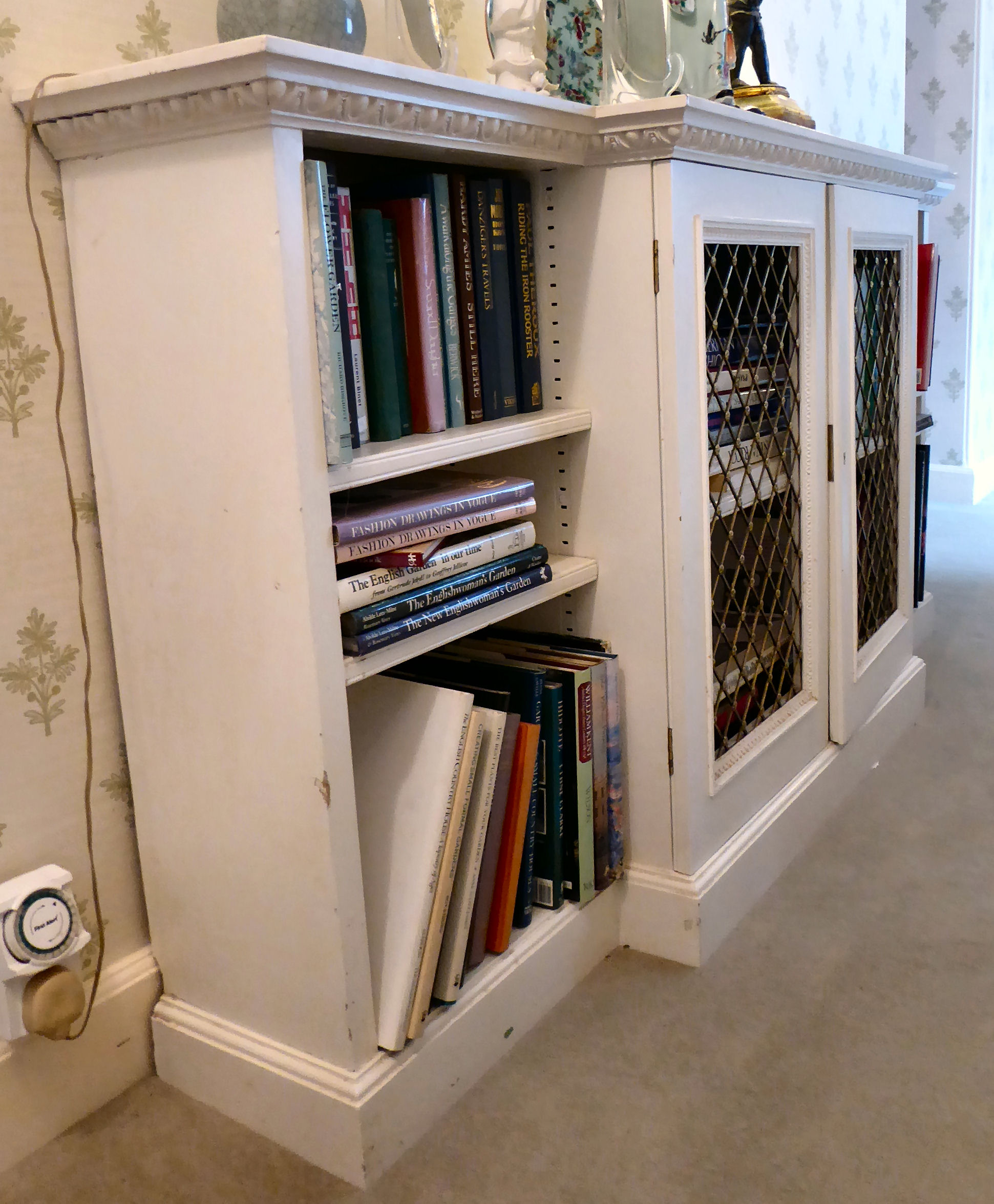 A mid 20thC white painted breakfront bookcase with two latticed brass central doors,