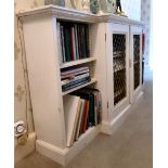 A mid 20thC white painted breakfront bookcase with two latticed brass central doors,