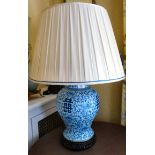 A modern Chinese Ming design porcelain table lamp, decorated in blue and white with dense flora,
