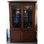 A Regency mahogany cabinet bookcase with a dentil moulded frieze,