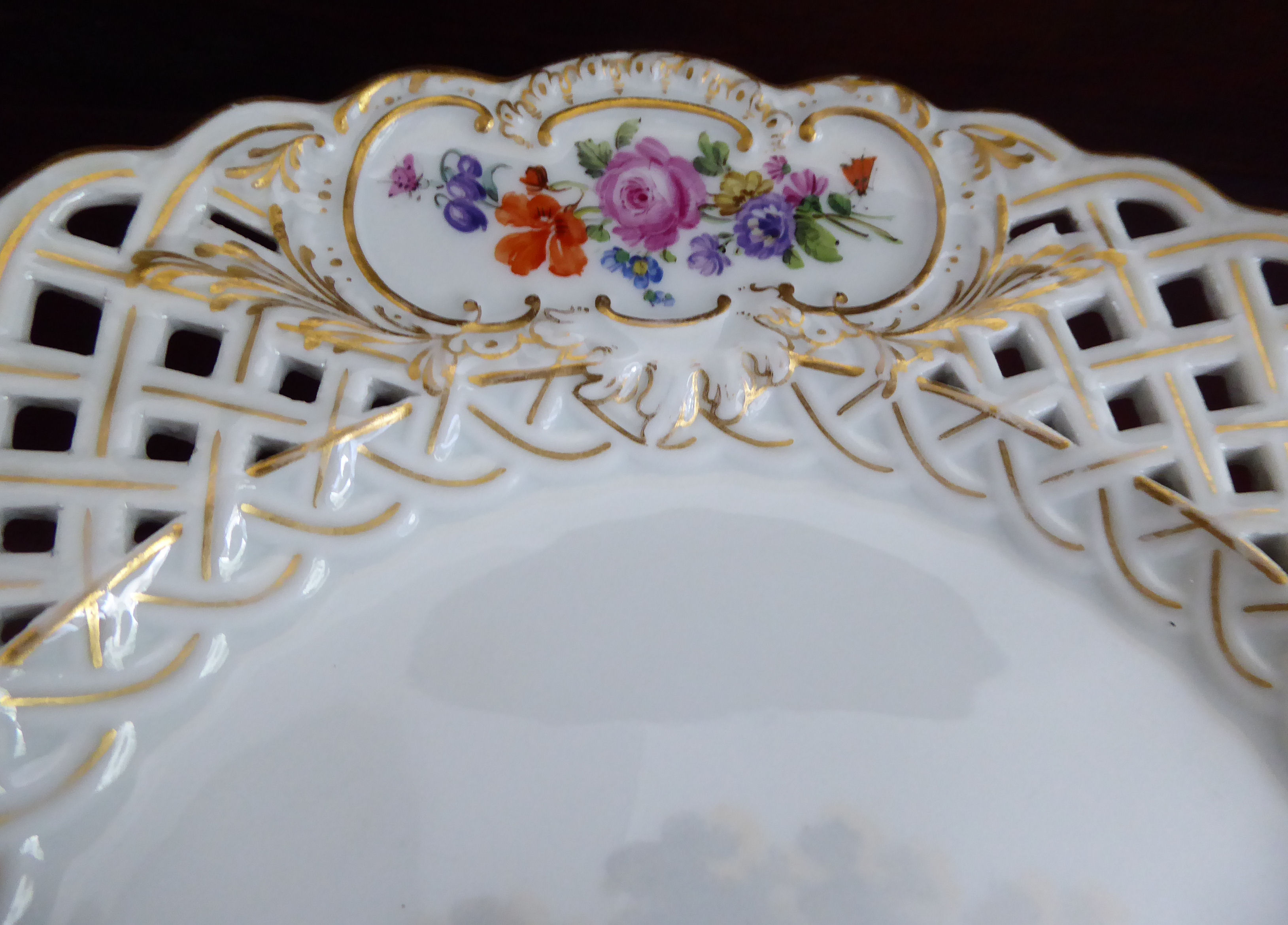 An early 20thC Meissen porcelain latticed plate with floral cartouches and figures wearing period - Image 3 of 6