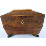 An early 19thC string inlaid burr walnut finished tea caddy with tapered sides and a hinged lid,