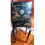 An early 20thC black lacquered and chinoiserie collector's cabinet on stand,