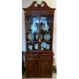 An Edwardian crossbanded and string inlaid mahogany cabinet bookcase with a swan neck pediment,