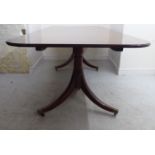 A 20thC Regency design mahogany dining table, the double D-end top with a central leaf,