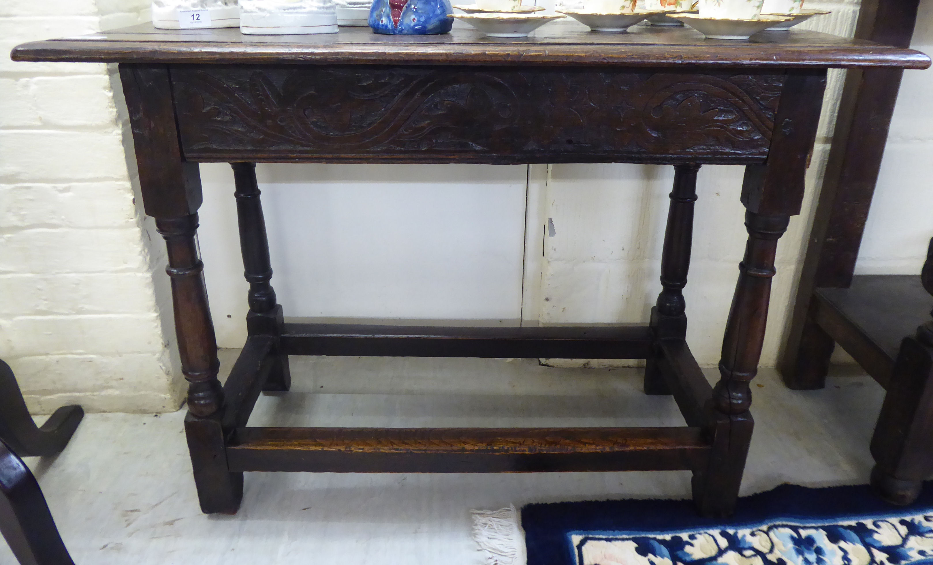 A late 18thC oak side table with a foliate carved frieze,