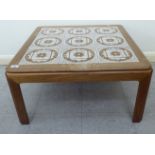 A modern teak framed coffee table with an inset nine tile top,