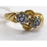 A 14ct gold diamond and sapphire petal design cross-over ring 11