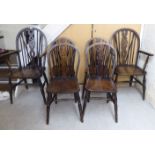 A mid 20thC set of six beech and elm framed wheelback dining chairs with solid seats,