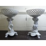 A pair of early 20thC CP & Co ivory glazed, porcelain table centrepieces, fashioned as maidens,