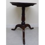 A George III stained oak tip-top pedestal table, raised on a ring turned,