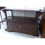 A 1930s (adapted) stained oak monk's bench, flanked by stick stand compartments,