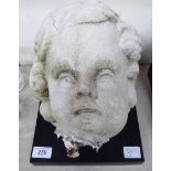 A composition stone cherubic head 10''h on a separate square black plinth T0S8