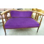 An Edwardian string inlaid mahogany two person window seat with a curved back and reeded,