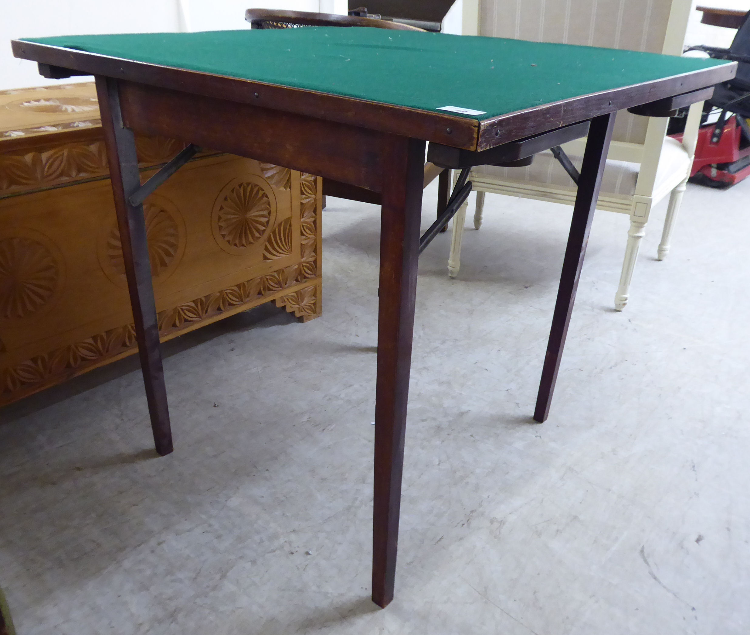 A mid 20thC stained beech framed card table, raised on folding, square,