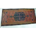 A Caucasian rug, decorated with a central medallion and stylised designs,