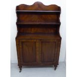 A late Regency inspired mahogany cabinet bookcase with a two tier waterfall front superstructure,