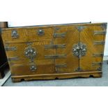 A 20thC Chinese lacquered, honey coloured oak table cabinet with engraved brass mounts and fittings,