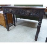 A late Victorian oak hall table with two frieze drawers, carved with lion mask motifs,