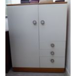 A 1970s Art Deco inspired teak and white painted compactum with a pair of doors and three drawers,
