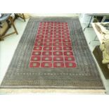 A Persian rug decorated with four columns of twelve octagonal guls,