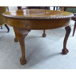 A 1930s mahogany coffee table, the top with a reeded edge, raised on cabriole legs,