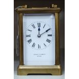 An early 20thC carriage clock with a lacquered brass case,