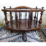 A late Victorian walnut Canterbury of oval form, the three sections with turned,