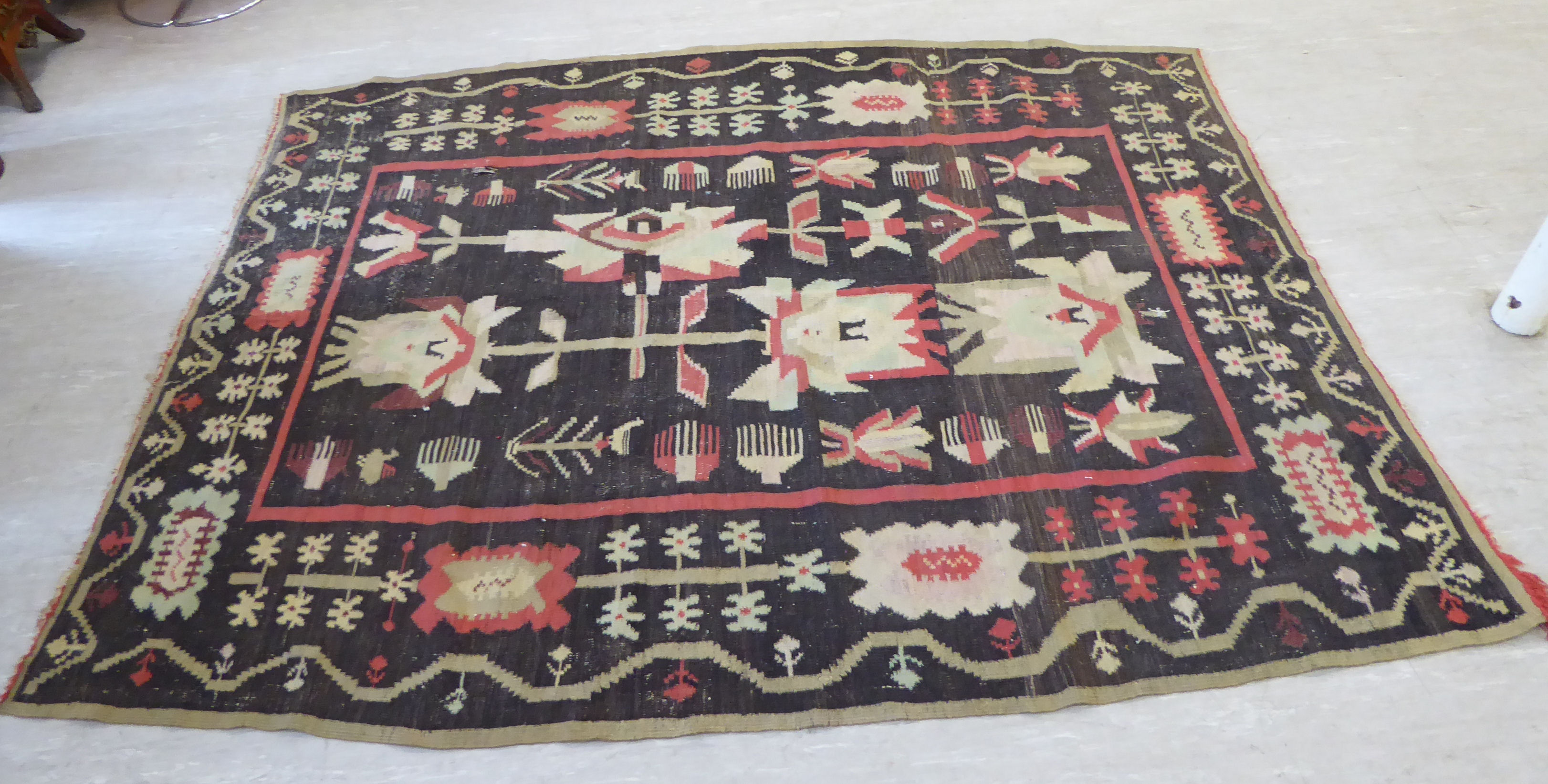 A Caucasian Kelim carpet, decorated with stylised abstract designs,