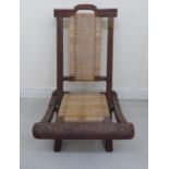 A late 19thC Colonial profusely carved wooden crossover framed folding veranda chair with a woven