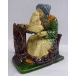 A late 19thC moulded pottery figure, a seated woman working at a spinning wheel 6.