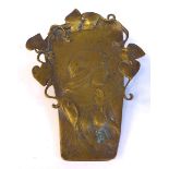 An Art Nouveau cast brass paperclip, on a sprung copper backplate,