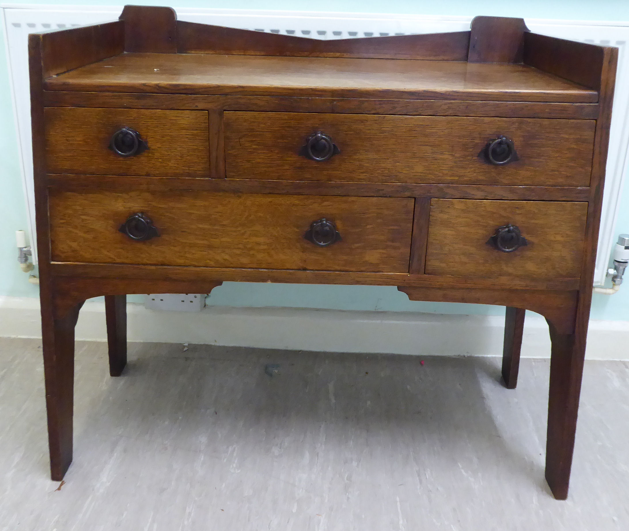 An early 20thC Arts & Crafts boarded oak dressing chest in the manner of Liberty,