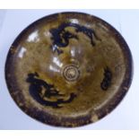 A Chinese pottery bowl, decorated with dragon silhouettes,