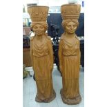 A pair of modern, carved honey coloured hardwood figural pillars,