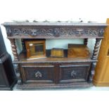 A late Victorian carved oak buffet, the top having a low upstand,