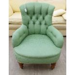 An early 20thC nursing chair, the part button green fabric upholstered back, arms and seat,