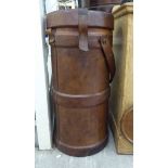 A leather clad cylindrical ammunition carrier with a brown hide strap 30''h 14''dia F