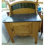 An early 20thC waxed pine washstand, the high back incorporating a line of green glazed tiles,